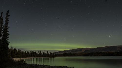 Scenic view of lake against sky at night