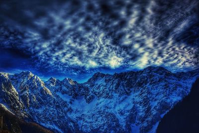 Scenic view of snowcapped mountain against cloudy sky