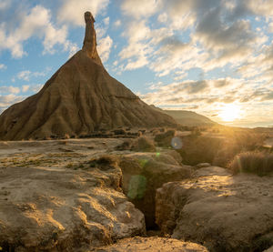 Rock formations on landscape against sky during sunset