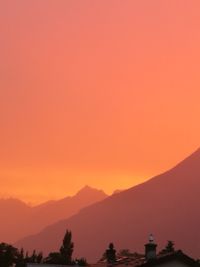 Scenic view of silhouette mountains against orange sky