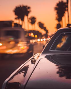 Car on street against sky at sunset