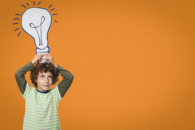 Portrait of boy standing against wall