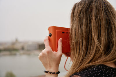 Female traveler taking picture with vintage instant camera