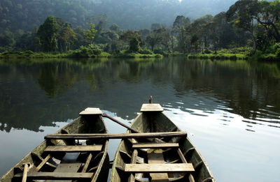 High angle view of wooden boats moored on lake by trees