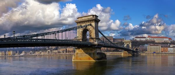 View of bridge over river against cloudy sky