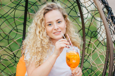 Portrait of a smiling young woman drinking glass