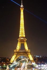 Low angle view of illuminated city against sky at night