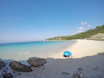 Scenic view of beach against blue sky