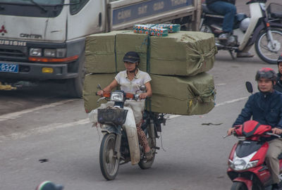 People riding motorcycle on road in city