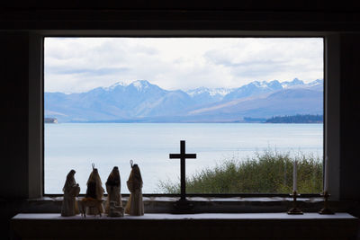 Scenic view of mountains against sky seen through window