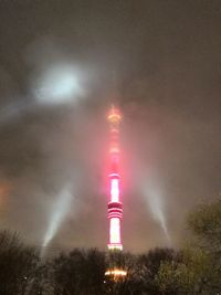 Low angle view of illuminated tower against sky at night