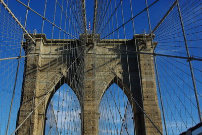 Low angle view of brooklyn bridge against blue sky