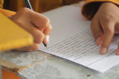 People writing paragraphs using pen on paper in indonesian language competition