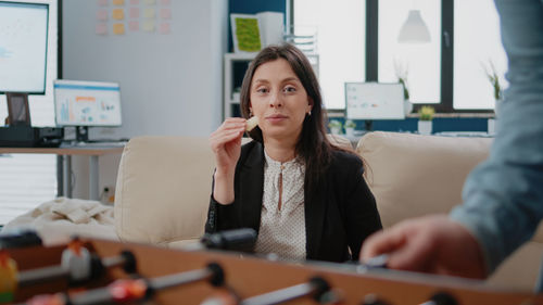 Young woman using mobile phone while sitting at home