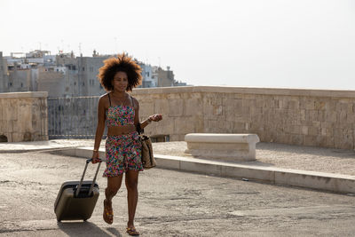 Full length of woman standing against wall