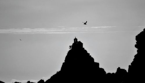 Low angle view of silhouette birds flying against sky