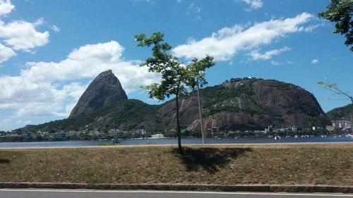 Scenic view of mountain by sea against sky