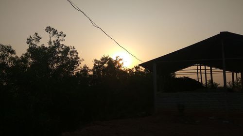 Silhouette trees against clear sky during sunset