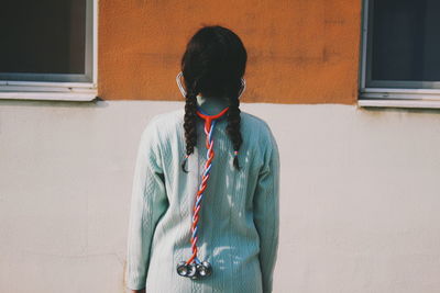 Full length of woman standing against wall