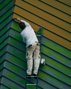 Rear view of man working on shutter