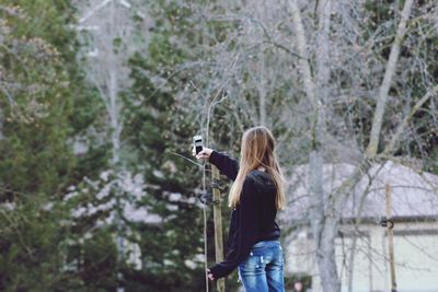 Woman photographing in forest