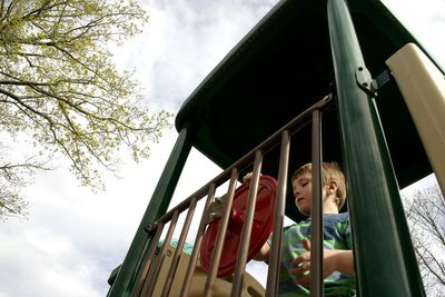 Low angle view of boys on slide against sky