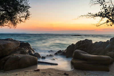 Motion wave seascape through stone arch at dawn in ko man klang, rayong, thailand. siam