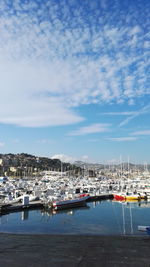 Boats moored at harbor against sky