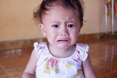 Portrait of cute baby crying at home