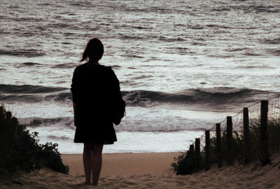 Rear view of woman walking on beach