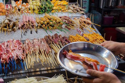 Midsection of person preparing food in restaurant at market