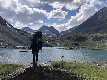 Full length of woman standing on lake against mountains