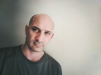 Portrait of mid adult man standing against wall at home