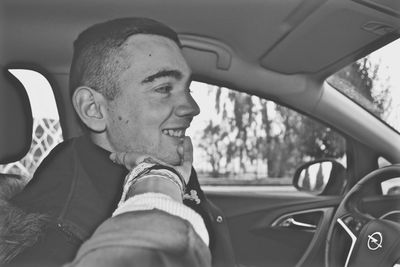 Close-up of smiling man sitting in car