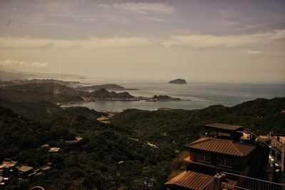 High angle view of buildings by sea against sky