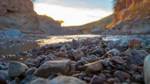 Surface level of stones against sky during sunset