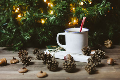 Close-up of drink by christmas tree on floor