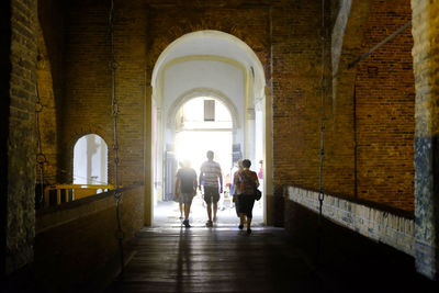 Rear view of people walking in corridor of building