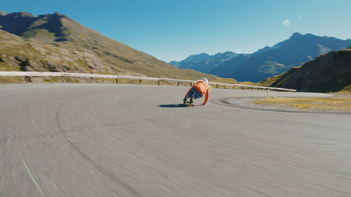 Rear view of man walking on road