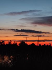 Silhouette landscape against dramatic sky during sunset