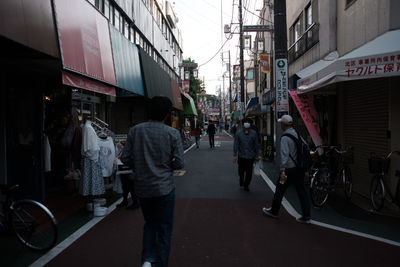 Rear view of man walking on bicycle in city