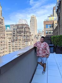 Portrait of man standing against buildings in city