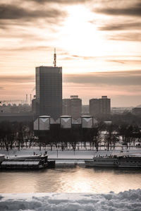 View of buildings at waterfront during sunset