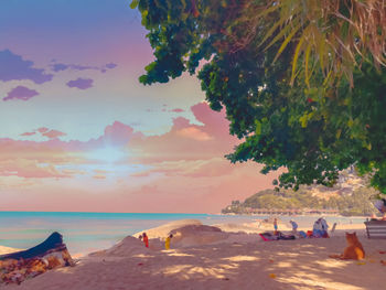 People on beach against sky during sunset