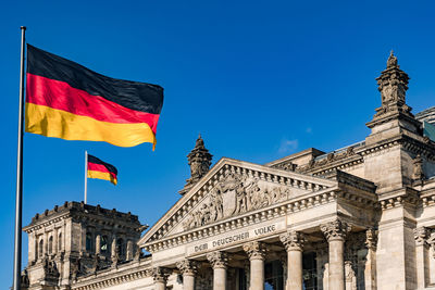 The federal flag in front of the impressive reichstag in berlin as a symbol of democracy