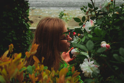 Woman with long hair by flowers
