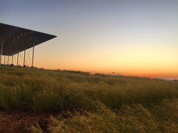 Scenic view of field against clear sky at sunset