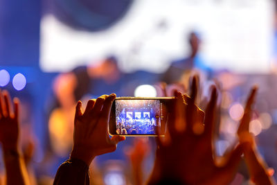 The audience records videos and takes photos with their smartphones during the concert.