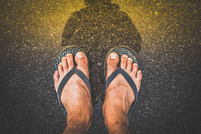 Low section of man standing in puddle