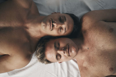 Portrait of two boys with moustaches face to face with their eyes closed